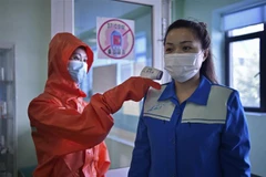 Nhân viên y tế kiểm tra thân nhiệt trước khi vào một nhà máy ở Bình Nhưỡng, Triều Tiên, ngày 16/6/2022. (Ảnh: AFP/TTXVN) 