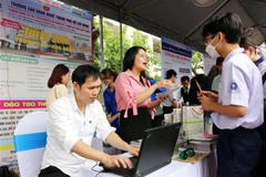 Các thầy cô giáo Trường Cao đẳng nghề Thành phố Hồ Chí Minh tư vấn, hướng nghiệp cho các em học sinh. (Ảnh: Thanh Vũ/TTXVN)