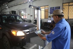 Đăng kiểm viên Trung tâm đăng kiểm xe cơ giới 1101S kiểm định xe cơ giới đường bộ. (Ảnh: Chu Hiệu/TTXVN)
