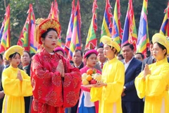 Chủ tế nữ mặc bộ lễ phục mầu đỏ thực hiện nghi thức tế lễ truyền thống. (Ảnh: Trung Kiên/TTXVN)