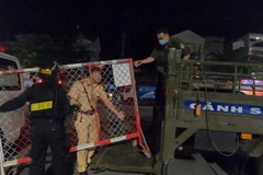 Sáng sớm 10/2, lực lượng chức năng thành phố Thủ Dầu Một, tỉnh Bình Dương tháo gỡ điểm phong tỏa khu vực phường Phú Hòa và Trường Đại học Thủ Dầu Một. (Ảnh: Chí Tưởng/TTXVN) 