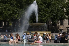 Người dân làm mát tại đài phun nước do nắng nóng gay gắt ở London, Anh ngày 17/6/2022. (Ảnh: AFP/TTXVN)