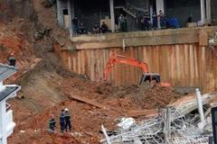 Lực lượng cứu hộ tìm kiếm những người mất tích trong vụ sạt lở nghiêm trọng xảy ra tại hẻm 36, đường Hoàng Hoa Thám, phường 10, thành phố Đà Lạt, Lâm Đồng. (Ảnh: Chu Quốc Hùng/TTXVN)