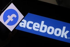 Biểu tượng Facebook trên màn hình máy tính và điện thoại di động. (Ảnh: AFP/TTXVN)