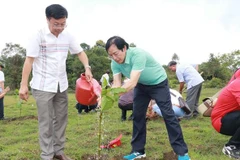 Đại diện lãnh đạo Thông tấn xã Việt Nam khu vực phía Nam và Hội Nhà báo trồng cây xanh tại trảng cỏ Bù Lạch, xã Đồng Nai, huyện Bù Đăng. (Ảnh: Đậu Tất Thành/TTXVN)