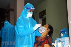 Cán bộ y tế lấy mẫu xét nghiệm cho người dân xã Hưng Đông, thành phố Vinh (Nghệ An). (Ảnh: Tá Chuyên/TTXVN) 