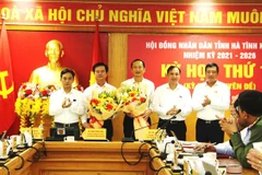 Tân Phó Chủ tịch Ủy ban Nhân dân tỉnh Trần Báu Hà (Thứ 2, từ trái qua) nhận hoa chúc mừng của lãnh đạo tỉnh Hà Tĩnh. (Ảnh: Phan Quân/TTXVN) 