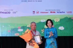 Tổng Giám đốc TTXVN Vũ Việt Trang trao Giải thưởng lớn “Hiệp sỹ Dế mèn” và chứng nhận cho nhà văn Trần Đức Tiến với truyện dài “A lô! Cậu đấy à.” (Ảnh: Hoàng Hiếu/TTXVN)