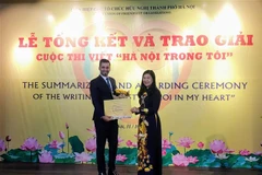 Chủ tịch Ủy ban Mặt trận Tổ quốc Việt Nam thành phố Hà Nội Nguyễn Lan Hương trao giải Nhất cho thí sinh Saleem Hammad đến từ Palestine. (Ảnh: Nguyễn Cúc/TTXVN) 