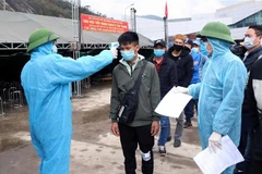 Kiểm tra thân nhiệt tại điểm tiếp nhận cách ly tập trung Cửa khẩu Quốc tế Cầu Treo. (Ảnh: Công Tường/TTXVN) 