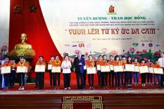 Trao tặng Bằng khen cho các học sinh là con, cháu thương binh, nạn nhân chất độc da cam/dioxin tiêu biểu, vượt khó vươn lên, giành kết quả xuất sắc trong học tập và rèn luyện, ngày 27/8/2017. (Ảnh: An Đăng/TTXVN) 