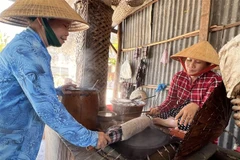 Công đoạn lấy bánh tráng. (Ảnh: Ánh Tuyết/TTXVN)