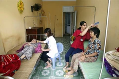 Cán bộ Trung tâm Bảo trợ xã hội và Công tác xã hội tỉnh Hưng Yên chăm sóc người cao tuổi cô đơn không nơi nương tựa. (Ảnh: Phạm Kiên/TTXVN) 