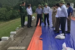 Đoàn công tác của Văn phòng Ban chỉ huy Phòng chống thiên tai và tìm kiếm cứu nạn Trung ương kiểm tra sự cố trên thân đập hồ sông Mực (huyện Như Thanh, tỉnh Thanh Hóa). (Ảnh: Hoa Mai/TTXVN) 