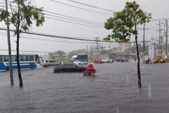 Nhiều xe chết máy khi đi qua đoạn ngập Suối Cát trên đại lộ Bình Dương thuộc địa bàn giáp ranh giữa thành phố Thủ Dầu Một và thành phố Thuận An. (Ảnh: TTXVN) 