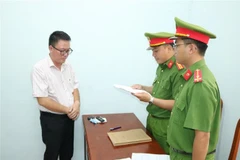 Cơ quan Cảnh sát Điều tra Công an tỉnh Trà Vinh thi hành các quyết định đối với Lê Hoàng. (Ảnh: TTXVN phát)