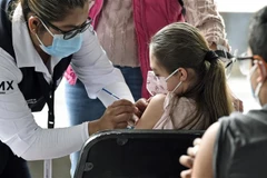 Nhân viên y tế tiêm vaccine phòng COVID-19 cho trẻ em tại Mexico City, Mexico, ngày 25/10/2021. (Ảnh: AFP/TTXVN) 