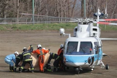 Lực lượng cứu hộ chuyển nạn nhân trong vụ chìm tàu du lịch từ trực thăng cứu hộ tới xe cứu thương tại đảo Hokkaido, Nhật Bản ngày 24/4. (Ảnh: AFP/TTXVN) 