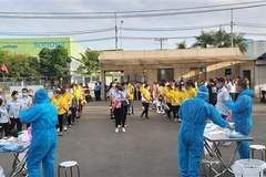 Các công nhân tại Bình Dương được test COVID-19 trước khi bắt đầu vào làm việc sau thời gian nghỉ Tết. (Ảnh: TTXVN phát) 