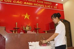 Thượng úy Trần Thị Thủy thắp hương tại phòng truyền thống tưởng niệm 64 liệt sỹ tại Lữ đoàn 146, Bộ Tư lệnh Vùng 4 Hải quân. (Nguồn: TTXVN) 