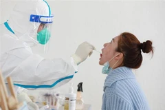 Lấy mẫu xét nghiệm COVID-19 cho người dân tại Hàng Châu, Trung Quốc ngày 11/3/2022. (Ảnh: AFP/TTXVN) 