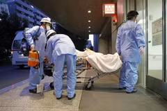 Nhân viên y tế chuyển bệnh nhân COVID-19 tới bệnh viện ở Tokyo, Nhật Bản. (Ảnh: Kyodo/TTXVN) 
