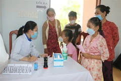 Y, bác sỹ bệnh viện Nhi đồng 2 (Thành phố Hồ Chí Minh) khám tổng quát, kiểm tra sức khỏe, tầm soát dinh dưỡng cho trẻ em có hoàn cảnh khó khăn xã Thạnh Phước. (Ảnh: Huỳnh Phúc Hậu/TTXVN)