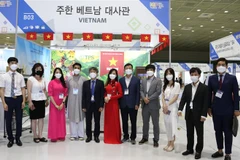 Đại sứ Việt Nam tại Hàn Quốc Nguyễn Vũ Tùng chụp ảnh lưu niệm với cán bộ Thương vụ và đại diện doanh nghiệp nhập khẩu hàng nông sản Việt Nam tại Hội chợ. (Ảnh: Mạnh Hùng/TTXVN) 