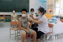 Tiêm vaccine phòng COVID-19 cho trẻ từ 5 đến dưới 12 tuổi tại trường tiểu học Lương Khánh Thiện, thành phố Phủ Lý, Hà Nam. (Ảnh: Nguyễn Chinh/TTXVN)
