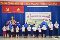 Tặng quà cho thiếu nhi có hoàn cảnh khó khăn tại xã Đông Thạnh, huyện Hóc Môn (Thành phố Hồ Chí Minh). (Ảnh: Hồng Giang/TTXVN). 