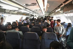 Người dân Afghanistan trên máy bay chuẩn bị rời sân bay Kabul ngày 16/8/2021. (Ảnh: AFP/TTXVN) 