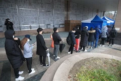 Các nhân viên một trung tâm chăm sóc khách hàng bị nghi nhiễm COVID-19 xếp hàng chờ lấy mẫu xét nghiệm bệnh phẩm tại khu y tế dựng tạm ở Seoul, ngày 10/3/2020. (Nguồn: Yonhap/TTXVN) 