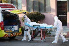 Nhân viên y tế chuyển bệnh nhân nhiễm COVID-19 lên xe cứu thương tại thành phố Daegu, Hàn Quốc ngày 21/2/2020. (Nguồn: AFP/TTXVN) 