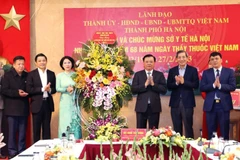 Bí thư Thành ủy Hà Nội Đinh Tiến Dũng chúc mừng ngành Y tế thủ đô. (Ảnh: TTXVN)