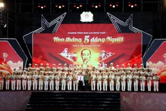 Lãnh đạo Bộ Công an, lãnh đạo tỉnh Nghệ An tặng kỷ niệm chương và hoa cho 75 gương điển hình tiên tiến Công anh nhân dân học tập, làm theo Sáu điều Bác Hồ dạy được tôn vinh tại buổi lễ. (Ảnh: Văn Tý/TTXVN)