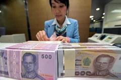 Nhân viên ngân hàng kiểm đếm đồng Baht tại Bangkok, Thái Lan. (Ảnh: AFP/TTXVN)