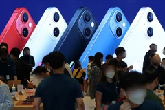 Khách hàng trải nghiệm điện thoại iPhone. (Ảnh: Yonhap/TTXVN) 