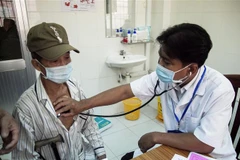 Bác sỹ Danh Ngọc Châu khám bệnh cho người dân tại Phòng khám Trung tâm Y tế huyện Châu Thành. (Ảnh: Hồng Đạt/TTXVN) 