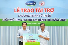 Ông Đỗ Thanh Tuấn, Giám đốc Đối Ngoại Vinamilk (bên trái) đại diện trao kinh phí hỗ trợ chương trình mổ tim miễn phí cho các bệnh nhi có hoàn cảnh khó khăn. (Nguồn: Vietnam+) 