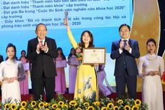 Phó Thủ tướng Thường trực Trương Hòa Bình và ông Nguyễn Anh Tuấn (bên phải), Bí thư thứ nhất Trung ương Đoàn, Chủ tịch Hội Liên hiệp Thanh niên Việt Nam tuyên dương 'Sinh viên 5 tốt' cấp Trung ương. (Ảnh: Văn Điệp/TTXVN) 