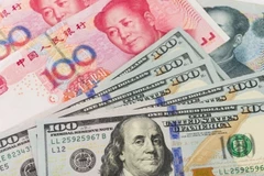 Đồng nhân dân tệ và đồng USD. (Ảnh: AFP/TTXVN) 