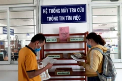 Người lao động tìm kiếm thông tin doanh nghiệp tuyển dụng việc làm tại Bình Dương. (Ảnh: Chí Tưởng/TTXVN) 
