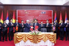 Chủ tịch Ủy ban Trung ương Mặt trận Tổ quốc Việt Nam Đỗ Văn Chiến và Chủ tịch Ủy ban Trung ương Mặt trận Lào xây dựng đất nước Sinlavong Khoutphaythone trao Biên bản hợp tác giữa hai Cơ quan giai đoạn 2022-2026. (Ảnh: Phạm Văn Kiên/TTXVN) 