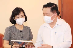 Phó Tổng Giám đốc Thông tấn xã Việt Nam Vũ Việt Trang giới thiệu các ấn phẩm của TTXVN với đồng chí Nguyễn Trọng Nghĩa, Bí thư Trung ương Đảng, Trưởng ban Tuyên giáo Trung ương. (Ảnh: Nguyễn Điệp/TTXVN)