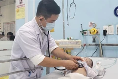 Bác sỹ Dư Tuấn Quy, Trưởng Khoa Nhiễm-Thần kinh, Bệnh viện Nhi đồng 1, Thành phố Hồ Chí Minh, khám cho bệnh nhi viêm màng não. (Ảnh: Đinh Hằng/TTXVN)