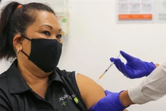 Nhân viên y tế tiêm vaccine phòng COVID-19 cho người dân tại Sydney, Australia. (Ảnh: AFP/TTXVN) 