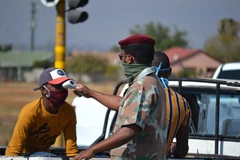 Binh lính Nam Phi kiểm tra thân nhiệt cho một người dân tại ngoại ô thủ đô Pretoria, Nam Phi. (Ảnh: Phi Hùng/TTXVN) 