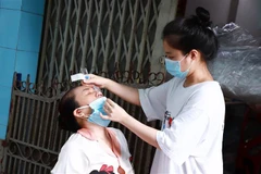 Người dân phường 4, quận 4 tự lấy mẫu xét nghiệm tại nhà. (Ảnh: Đinh Hằng/TTXVN) 