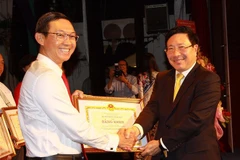 Phó Thủ tướng, Bộ trưởng Bộ Ngoại giao Phạm Bình Minh trao bằng khen cho 5 tập thể và 16 cá nhân có nhiều đóng góp tích cực cho ngành ngoại giao Việt Nam giai đoạn 2017-2019. (Ảnh: Thanh Vũ/TTXVN) 