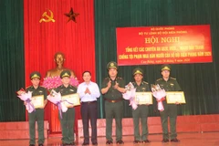 Đại diện lãnh đạo Bộ Tư lệnh Bộ đội Biên phòng tặng Bằng khen cho các tập thể có thành tích xuất sắc trong đấu tranh chống tội phạm mua, bán người, góp phần giữ vững an ninh chính trị, trật tự an toàn xã hội khu vực biên giới. (Ảnh: Chu Hiệu/TTXVN) 